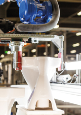 Industrirobotar hanterar med varsamma rörelser produkter i olika stadier av tillverkningen. Foto: Geberit